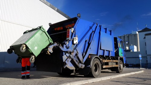 Skip hire truck at a residential driveway illustrating insured rubbish services